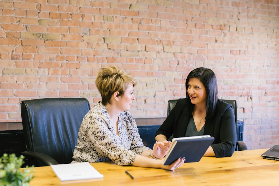 Two colleagues discussing a customer plan around a tablet